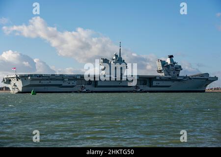 Schlepper, die einem britischen Kriegsschiff helfen. Die Flugzeugträgerin HMS Prince of Wales (R09) sah am 4/2/22 nach einer 3-wöchigen Arbeit nach Portsmouth, Großbritannien, zurückkehren. Stockfoto