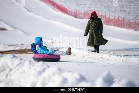 ZHANGJIAKOU, CHINA - 5. FEBRUAR 2022 - Touristen erleben Schneesport im touristischen Kulunnur-Gebiet in Zhangjiakou, der nordchinesischen Provinz Hebei, Fe Stockfoto