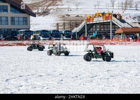 ZHANGJIAKOU, CHINA - 5. FEBRUAR 2022 - Touristen erleben Schnee-Go-Kart im Kulunnur Touristenzone in Zhangjiakou, Provinz Hebei in Nordchina, F Stockfoto