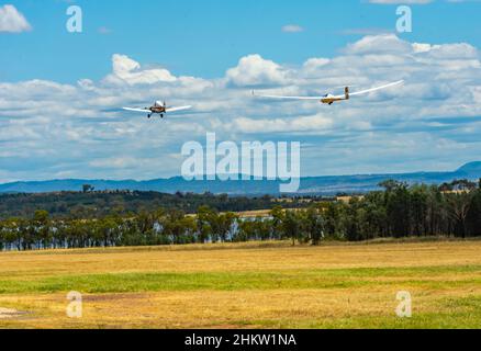 Piper Pawnee-Flugzeug mit einem Schempp-Hirth-Segelflugzeug über den Lake Keepit Gunnedah Australia. Stockfoto