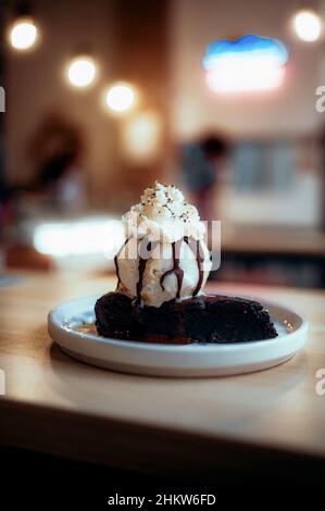 Nahaufnahme eines reichen Schokoladenbrownie mit Vanilleeis Stockfoto