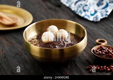 Koreanische Küche: Dongji Patjuk Red Bean Porridge, serviert auf Golden Bowl Stockfoto