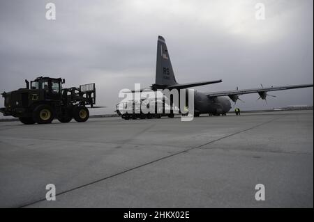 Ein 10K Geländestapler bereitet sich darauf vor, eine Gepäckpalette von einem C-130J Super Hercules Flugzeug zu empfangen, das der Airlift Squadron 37th am Flughafen Rzeszów-Jasionka, Polen, zugewiesen wurde, 4. Februar 2022. Mitglieder des Air Ground Operations Wings 435th kamen am 3. Februar in Polen an, um den Flughafen auf die Ankunft der US-Streitkräfte vorzubereiten. (USA Luftwaffe Foto von Senior Airman Taylor Slater) Stockfoto