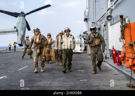 PHILIPPINISCHES MEER (Feb 5, 2022) U.S. Marines mit der 11th Marine Expeditionary Unit (MEU) eskortieren Brig. General Kyle Ellison, Kommandant General, 3rd Marine Expeditionary Brigade, III Marine Expeditionary Force, vor dem Flugdeck des amphibischen Sturmschiffs USS Essex der Wasp-Klasse (LHD 2) für einen Besuch bei angesehenen Besuchern während der Übung Noble Fusion, 5. Februar 2022. Noble Fusion zeigt, dass die Marine und das Marine-Korps im Vorlauf stationierte, einsatzbereite Marineeinsatzkräfte schnell Teams der Marine Expeditionary Unit/Amphibious Ready Group auf See zusammen mit einer Trägerstreikgruppe zusammenbringen können Stockfoto