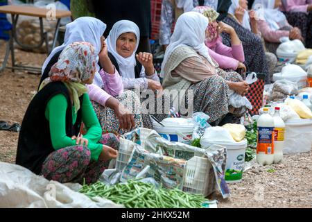 Türkische Frauen verkaufen verschiedene frische Lebensmittel wie Gemüse und Käse auf dem Kas Freitagsmarkt am türkischen Mittelmeer. Stockfoto