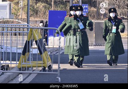 Peking, China. 06th. Februar 2022. Olympische Spiele, Feature. Soldaten gehen an einem Sperrzaun vorbei. Kredit: Peter Kneffel/dpa/Alamy Live Nachrichten Stockfoto