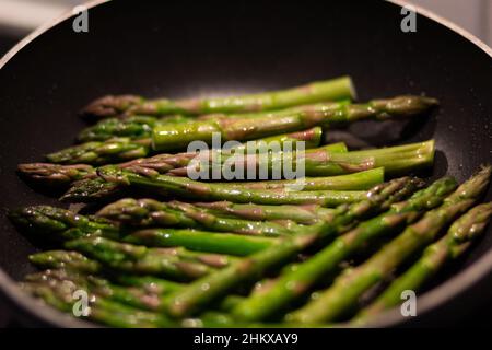 Braten von grünem Spargel in einer Pfanne Stockfoto