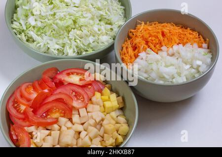 Rohes, gehacktes Gemüse in Schüsseln für die Suppe Stockfoto