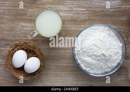 Molke, Eier und Mehl als Zutaten zum Backen und Kochen auf dem Holzhintergrund Stockfoto