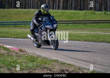 11-05-2021 Riga, Lettland Motorradfahrer bei Sportfahrrädern auf leerer Asphaltstraße. Sportmotorrad. MotoGP-Rennen. Superbikes. Motorradrennen. Motorcycl Stockfoto