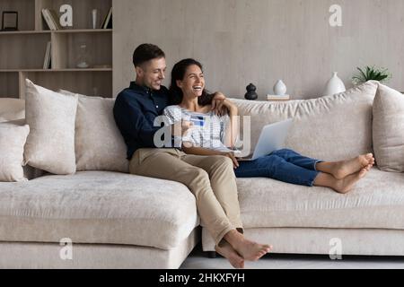 Aufgeregt Paar online mit Kreditkarte bezahlen, mit Laptop Stockfoto
