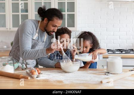 Glückliche afroamerikanische Familie kocht zusammen zu Hause. Stockfoto