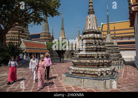 Bangkok, Thailand. 05th Feb, 2022. Tourists wearing facemasks as a precaution against the spread of covid-19 seen walking next to a pagoda at the Temple of the reclining Buddha.Thailand's government resumed the 'Test and Go' program on February 1, 2022 to welcome fully vaccinated visitors from all countries with extra disease control measures aimed at boosting the tourism industry and its economy amid the ongoing spread of the Omicron variant of covid-19. (Photo by Peerapon Boonyakiat/SOPA Images/Sipa USA) Credit: Sipa USA/Alamy Live News Stock Photo