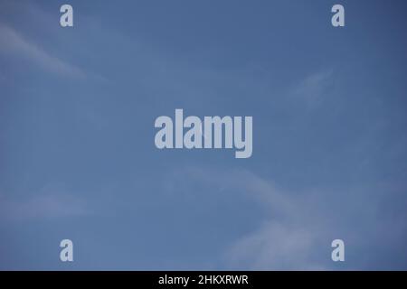 Halbmond am Tag, blauer Himmel mit ein paar Wolken Stockfoto