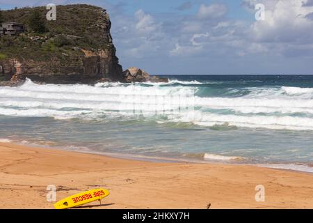 Avalon Beach in Sydney mit Blick auf Bangalley Head und Surfrescue Surfboard auf dem Sand, Sydney, Australien Stockfoto