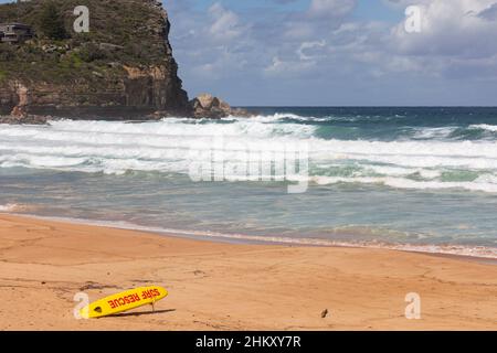 Avalon Beach in Sydney mit Blick auf Bangalley Head und Surfrescue Surfboard auf dem Sand, Sydney, Australien Stockfoto