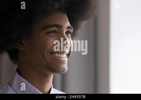 Glücklicher afrikanischer Teenager mit afro-afro-Frisur, der wegschaut Stockfoto