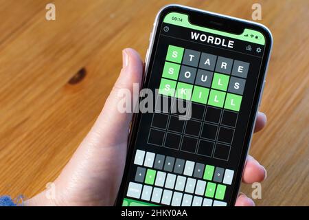 Startwort auf Wordle Stare und Finishing Work Skill. IPhone in der Hand gehalten. Stockfoto