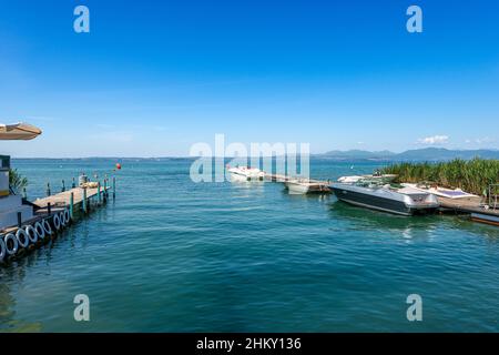 Kleiner Hafen an der Küste des Gardasees mit Schnellbooten zwischen dem Dorf Lazise und Bardolino, Ferienorte in der Provinz Verona, Venetien, Italien. Stockfoto