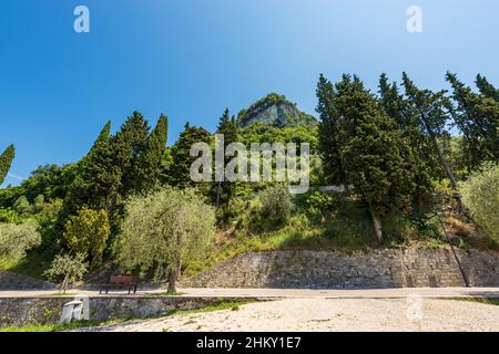 Der Hügel Rocca di Garda, an der Küste des Gardasees (Lago di Garda) mit der Fußgänger- und Fahrradstraße vor dem kleinen Dorf Garda Stockfoto