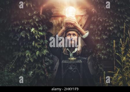 Alchemist in einem schönen dekorativen Kleid in der Natur. Stockfoto