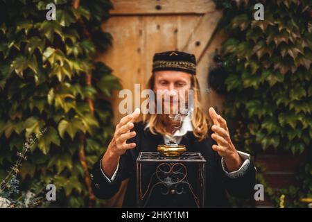 Alchemist in einem schönen dekorativen Kleid in der Natur. Stockfoto