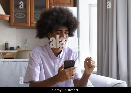 Fröhlich glücklich teen afrikanischen Kerl aufgeregt mit guten Nachrichten Stockfoto