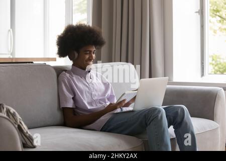 Glücklicher afrikanischer Schüler, der sich zu Hause auf den Test vorbereitet Stockfoto