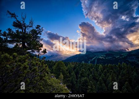 Gipfel von Plattkofel, Grohmannspitze und Langkofel mit Gewitterwolken bedeckt, von unterhalb des Pordoi-Passes bei Sonnenuntergang gesehen. Stockfoto