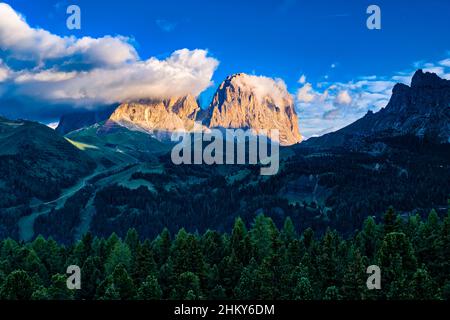 Gipfel von Plattkofel und Grohmannspitze (bedeckt mit Wolken) und Langkofel, Felswände der Sellagruppe auf der rechten Seite, von unterhalb des Pordoi-Passes gesehen Stockfoto