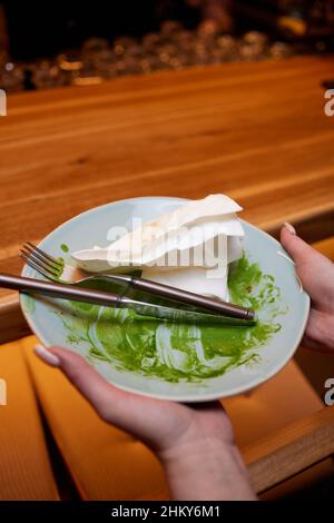 Der Prozess des Essens von Pasta Fettuccine mit Spinatblättern und grünen Erbsen. Schmutzige Gerichte. Vegetarische Küche. Italienisches Essen Stockfoto