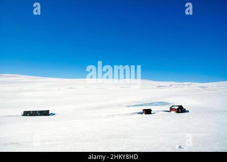 Häuser in den schneebedeckten Ebenen der Hardangervidda Stockfoto