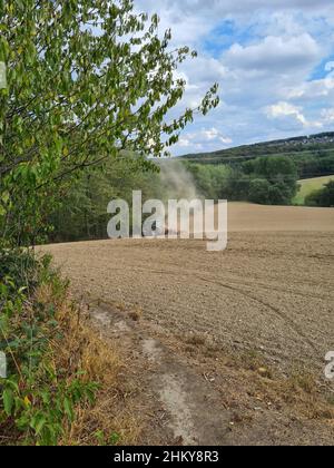 Moderner roter Traktor, der direkt in den Stoppeln sät, mit roter Ausrüstung und GPS für die Präzisionslandwirtschaft auf den Feldern Stockfoto