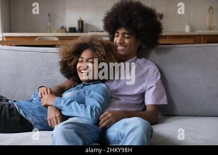 Glückliches Dating Teenager-Paar in der Liebe entspannen auf der Couch zu Hause Stockfoto
