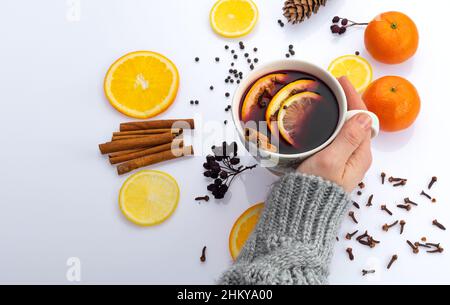 Die Hände der Frauen halten eine Tasse Tee. Hände mit Pullover mit einer Tasse Tee, Winter- und Herbstkonzept Stockfoto