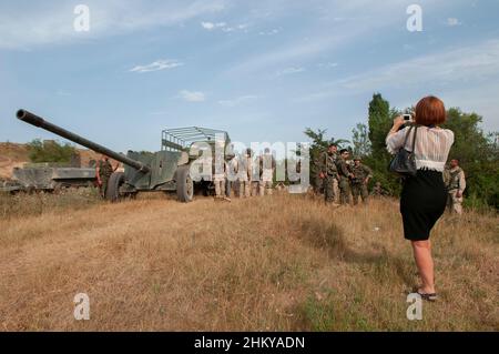 Ein deutscher Journalist fotografiert mit einer kleinen Kamera eine georgische Artillerieeinheit in der Nähe des Dorfes Igoeti während des russisch-georgischen Krieges im August 2008 Stockfoto