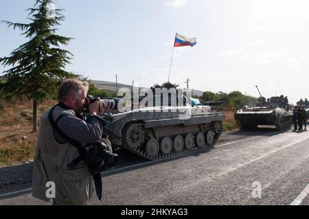 Ein Fotojournalist fotografiert mit einer Canon DSLR-Kamera und einem Teleobjektiv russische Truppen am Stadtrand von Gori während des russisch-georgischen Krieges im August 2008 Stockfoto