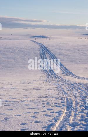 Spuren eines Schneemobils auf einer schneeweißen Tundra-Landschaft. Autonomer Kreis Jamal-Nenzen, Russland Stockfoto