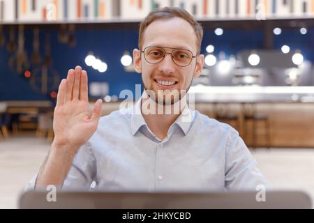 Glücklich junge kaukasischen Mann Blogger sitzen im Einkaufszentrum Blick auf Kamera tun Online-Job Interview während Video-Chat-Konferenz Webcam-Ansicht Stockfoto