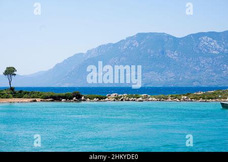 Blick auf die Insel Sedir aus der Ferne. Die Insel Sedir (türkisch: Sedir Adasi), auch bekannt als Kleopatra-Insel, ist eine kleine Insel im Golf von Gokova Stockfoto