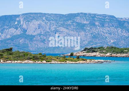 Blick auf die Insel Sedir aus der Ferne. Die Insel Sedir (türkisch: Sedir Adasi), auch bekannt als Kleopatra-Insel, ist eine kleine Insel im Golf von Gokova Stockfoto