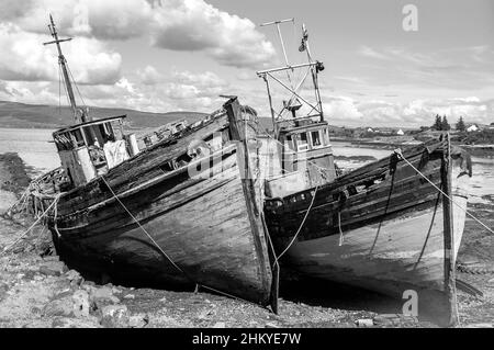 Schwarz-Weiß-Foto von zwei verlassenen hölzernen Heringsfischern an der Küste der Isle of Mull, Argyll, Inner Hebrides, Schottland, Großbritannien, Europa Stockfoto