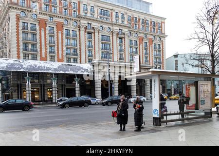 Moskau, Russland - am 25. Januar 2021 stehen Menschen an einer Bushaltestelle, die auf einen Bus in der Tverskaya Street gegenüber dem Ritz-Carlton Hotel wartet Stockfoto