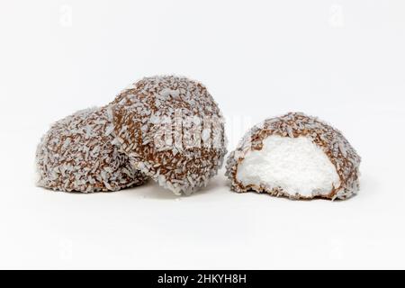 Schneeballkuchen gefüllt mit weichem Moorgelchen, bedeckt mit Schokolade und Kokosnuss Stockfoto