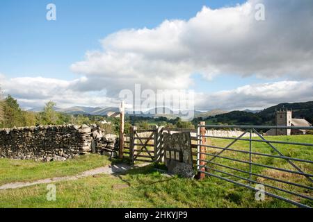 Fußwegschild und Tor, das nach St. Michael und alle Angels Church Hawkshead der Lake District Cumbria England führt Stockfoto