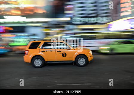 Ein gelbes Taxi fährt schnell durch den Times Square in NYC, USA Stockfoto