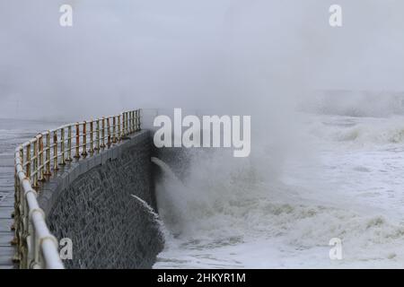 Aberystwyth Wales Vereinigtes Königreich Wetter Februar 6th 2022 . An einem kalten Wintertag an der Westküste großbritanniens treiben starke Winde mit beißender Kälte die riesigen Wellen bei Flut, wobei Schäden an Strukturen und Eigentum möglich sind. Kredit: mike davies/Alamy Live Nachrichten Stockfoto