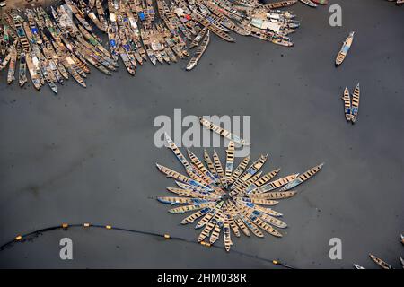 Luftaufnahme von Fischerbooten, die im Hafen von Tema, Greater Accra, Ghana, festgemacht sind und auf dem schmutzigen Wasser ein Blumenmuster bilden Stockfoto