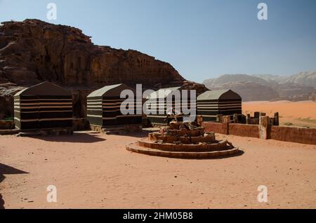 Schöne Aufnahme von einigen Camps in der Nähe einiger riesiger Klippen im Wadi Rum, Jordanien. Stockfoto