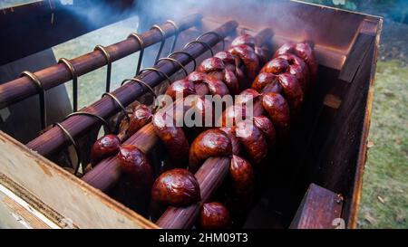 Hausgemachte Würstchen, die drinnen draußen hängen, hausgemachte raucherische Spezialitäten Stockfoto